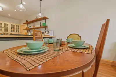 a wooden table with bowls and plates on it at Spacious Historic 8-Bedroom Manor in Short North - Perfect for Large Groups in Columbus