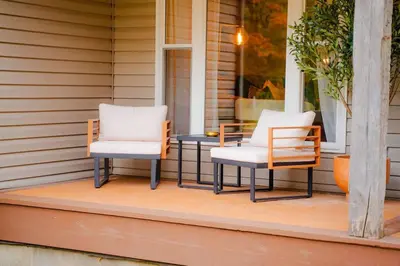 two chairs and a table on a porch at The 312 House - A Boho Retreat- Hocking Hills in Logan