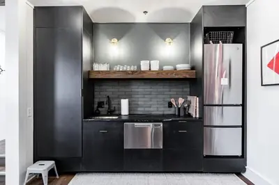 a kitchen with black cabinets and a stainless steel refrigerator at Riverfront Retreat - 2 Units - 3BR - Free Parking in Cleveland