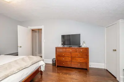 a bedroom with a bed and a dresser with a tv on it at Queen City Suites 2 - For 4 in Cincinnati