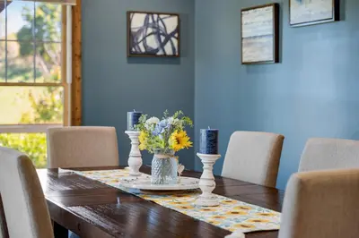 a dining room table with a vase of flowers on it at Calaboose Retreat in Campton