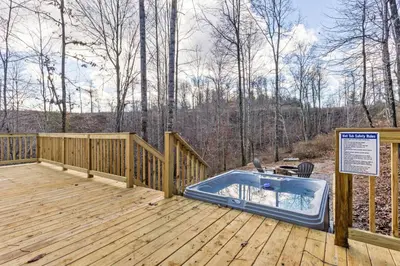 a hot tub on a wooden deck with a sign at Primrose - Cave Run Lake OR Red River Gorge KY in Wellington