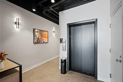 a hallway with a door and a picture on a wall at The 333 Suites 201 - Stay for 6 in Cincinnati