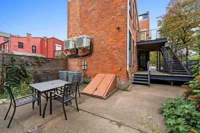a patio with a table and chairs in front of a brick building at Free Downtown Parking Walk to Stadiums and Shopping in Covington