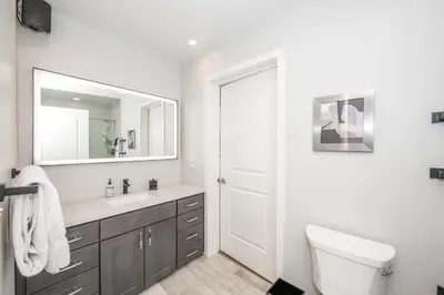 a bathroom with a sink and a toilet and a mirror at The 333 Suites - For 24 Guests in Cincinnati