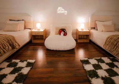 a room with two beds with a teddy bear sitting on a chair at The 312 House| A Boho Retreat| Hocking Hills in Logan
