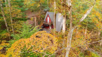 an aerial view of a small red cabin in the woods at Waterfront A- Frame with Dock, Canoe + Kayaks in Rockbridge