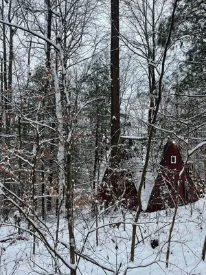a small red house in the woods in the snow at Waterfront A- Frame with Dock, Canoe + Kayaks in Rockbridge