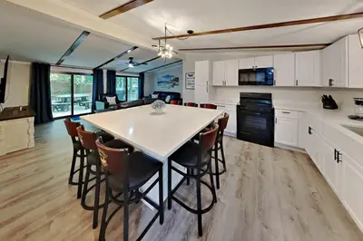 a kitchen with a large white table and chairs at Put-in-Bay Island Club #68 in Put-in-Bay