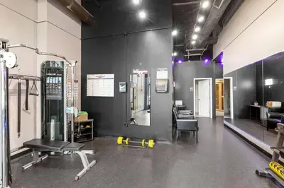 a room with a gym with a treadmill and a chair at Fun 2Bed Apt Skeeball Foosball FREE Parking in Cleveland