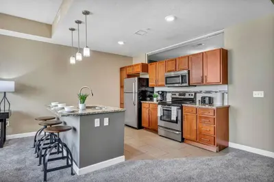 a kitchen with wooden cabinets and a counter top at LAKE VIEWS! 15th Floor Downtown High-Rise | Gym in Cleveland