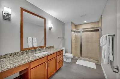 a bathroom with a sink and a toilet and a mirror at SkyTower 2BD | Parking Available | Downtown in Cleveland