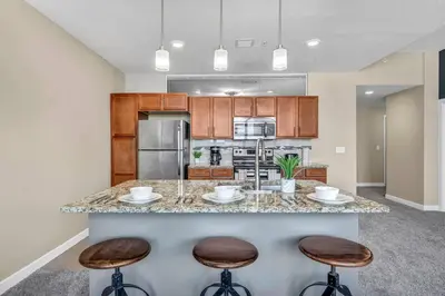 a kitchen with a large island with two bar stools at Luxury High-Rise • 18th Floor Condo • Parking $ in Cleveland