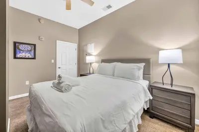 a bedroom with a large white bed and a lamp at Playhouse Square Flat • Pool Table in Cleveland