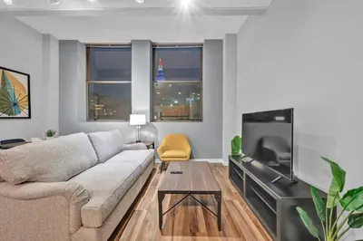 a living room with a couch and a flat screen tv at Central Downtown Condo | Parking & Pool Table in Cleveland