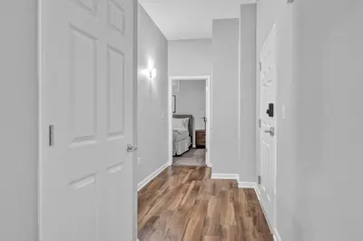 an empty hallway with white walls and wooden floors at Central Downtown Condo | Parking & Pool Table in Cleveland