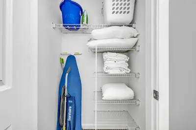 a closet with white towels and a blue surfboard at The Playhouse Suites 2BD | Downtown | Security in Cleveland