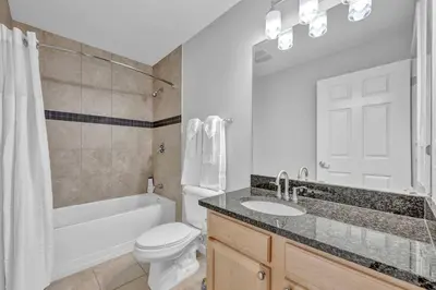 a bathroom with a white toilet and a sink and a tub at The Playhouse Suites 2BD | Downtown | Security in Cleveland