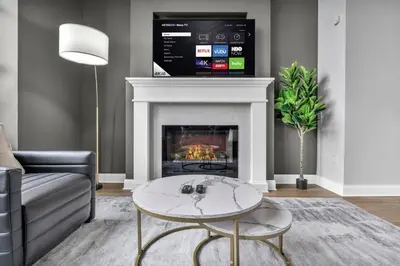 a living room with a fireplace with a tv above it at The Halle Downtown 1BD | Parking/Gym/Security in Cleveland