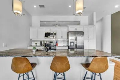 a kitchen with a large island with two bar stools at The Halle Downtown 1BD | Parking/Gym/Security in Cleveland