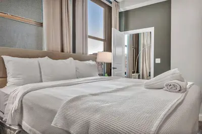 a bedroom with a large white bed with a window at Gorgeous Downtown Flat| Parking•Gym•Security in Cleveland
