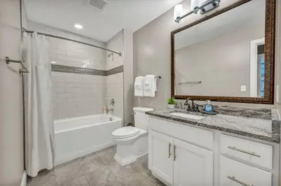 a bathroom with a sink toilet and a mirror at Gorgeous Downtown Flat| Parking•Gym•Security in Cleveland
