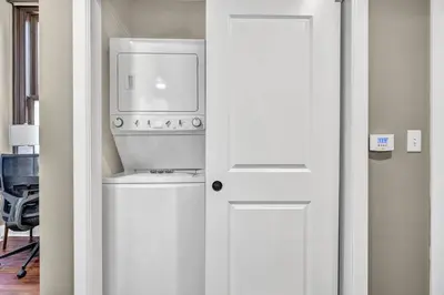 a kitchen with a washing machine and a white door at Amazing Downtown Apartment in Incredible Location! in Cleveland