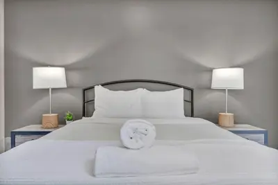 a white bed with two lamps on either side of it at Central Downtown Loft | Parking•Gym•Security in Cleveland
