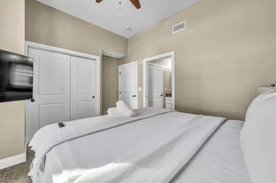 a bedroom with a large white bed and a tv at Elegant Downtown Apartment | Paid Parking & Gym in Cleveland