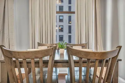 a dining room table with chairs and a window at Elegant Downtown Condo • Fitness Gym Included in Cleveland