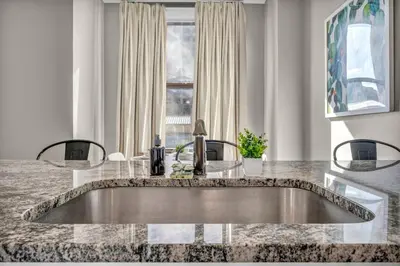 a kitchen with a sink in a marble counter top at Stunning Downtown Condo with Parking & Gym in Cleveland