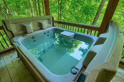 a jacuzzi tub on the deck of a cabin at Havenridge in Logan