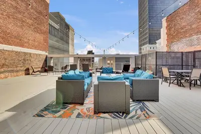 a patio with blue chairs and tables on a building at Rhythm & Blues 2 BD Repose Near Rock & Roll HOF in Cleveland