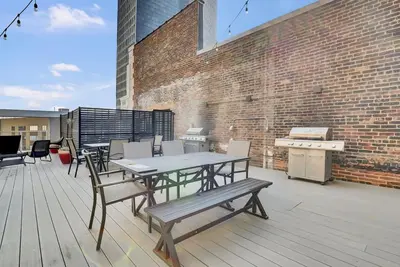 a patio with a table and chairs and a grill at Rhythm & Blues 2 BD Repose Near Rock & Roll HOF in Cleveland