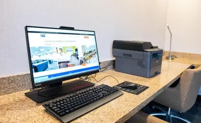 a computer monitor and a printer on a desk at Holiday Inn Express & Suites Ironton by IHG in Ironton