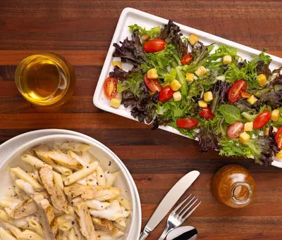 a table with a salad and a bowl of french fries at Drury Plaza Hotel Cleveland Downtown in Cleveland