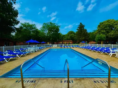 a swimming pool with blue chairs and blue umbrellas at Put-in-Bay Island Club #13 in Put-in-Bay