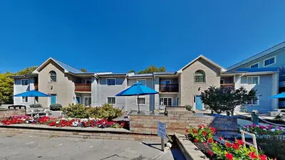 a large apartment building with umbrellas in a parking lot at Put-in-Bay Poolview Condo #4 in Put-in-Bay