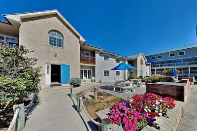 a building with a patio and flowers in front of it at Put-in-Bay Poolview Condo #4 in Put-in-Bay