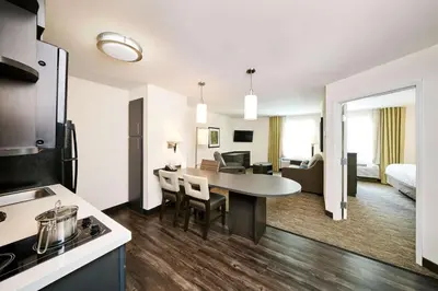 a kitchen and living room with a table in a room at Sonesta Simply Suites Columbus Airport Gahanna in Gahanna