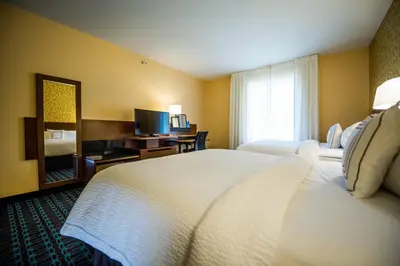 a hotel room with a bed and a television at Fairfield by Marriott Cambridge in Cambridge