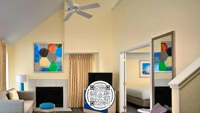 a living room with a ceiling fan and a bedroom at Sonesta Simply Suites Cleveland Airport in Middleburg Heights