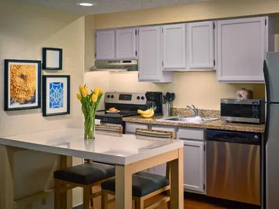 a kitchen with white cabinets and a white counter top at Sonesta Simply Suites Cleveland Airport in Middleburg Heights
