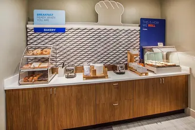 a bakery with a counter with donuts on it at Holiday Inn Express Hotel & Suites Dayton-Centerville by IHG in Centerville