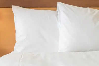a bed with white sheets and pillows on it at Holiday Inn Express Hotel & Suites Youngstown North-Warren/Niles by IHG in Warren