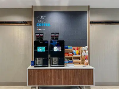 a coffee shop with a sign that says must have coffee at Holiday Inn Express Hotel & Suites Youngstown North-Warren/Niles by IHG in Warren
