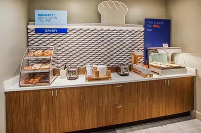 a bakery with a counter with donuts on it at Holiday Inn Express - Akron NW - Fairlawn by IHG in Akron
