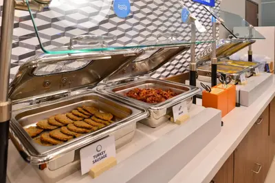 a buffet line with trays of food on a counter at Holiday Inn Express Lexington - Horse Park Area by IHG in Lexington