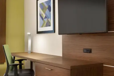 a room with a desk with a television on a wall at Holiday Inn Express & Suites - Cincinnati South - Wilder by IHG in Wilder