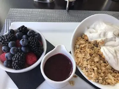 a tray with a bowl of fruit and a bowl of yogurt at Courtyard by Marriott Cincinnati Airport in Erlanger